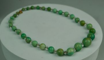 A JADE NECKLACE WITH ROCK CRYSTAL AND YELLOW METAL CLASP, 38.9gms