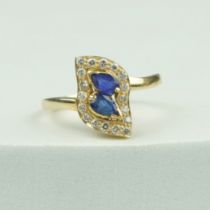 A GOLD RING 18CT SET WITH TWO CENTRAL PEAR DROP CUT SAPPHIRES,