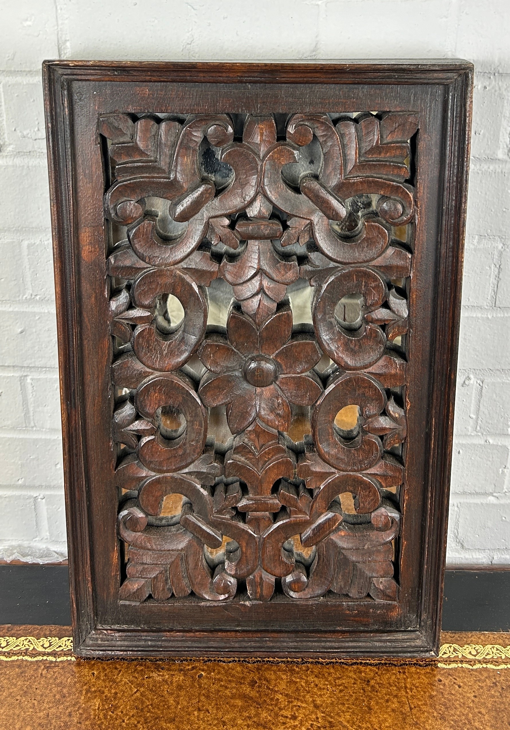 A CARVED FLORAL SCROLL OAK PANEL WITH MIRRORED BACK, 56cm x 35cm x 5cm