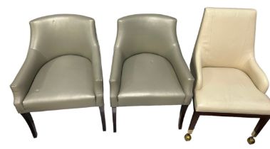 A PAIR OF ARMCHAIRS UPHOLSTERED IN GREY LEATHER ALONG WITH A SIMILAR ARMCHAIR WITH YELLOW METAL