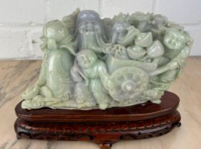 A CHINESE JADE GROUP ON ROSEWOOD STAND, Probably 20th Century or modern. Jade 20cm x 11cm