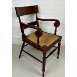 AN EARLY 20TH CENTURY ARMCHAIR OR DESK CHAIR, Flame mahogany with scroll arms and cane upholstered