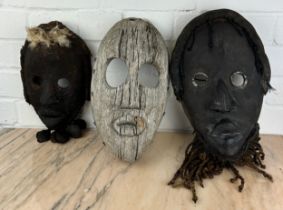 A GROUP OF THREE AFRICAN TRIBAL 'DAN' MASKS FROM LIBERIA, Largest 30cm x 18cm