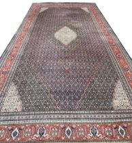 A VERY LARGE AND FINE PERSIAN CARPET WITH LABEL FROM HARRODS FOR £9,950,