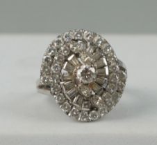 AN 18CT WHITE GOLD RING OF 'WHIRL' DESIGN SET WITH DIAMONDS, Weight: 6.9gms One baguette cut diamond
