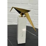 EICHOLTZ: A MODERNIST TABLE SCULPTURE OF A GILT BRASS BIRD ON A MARBLE STAND.