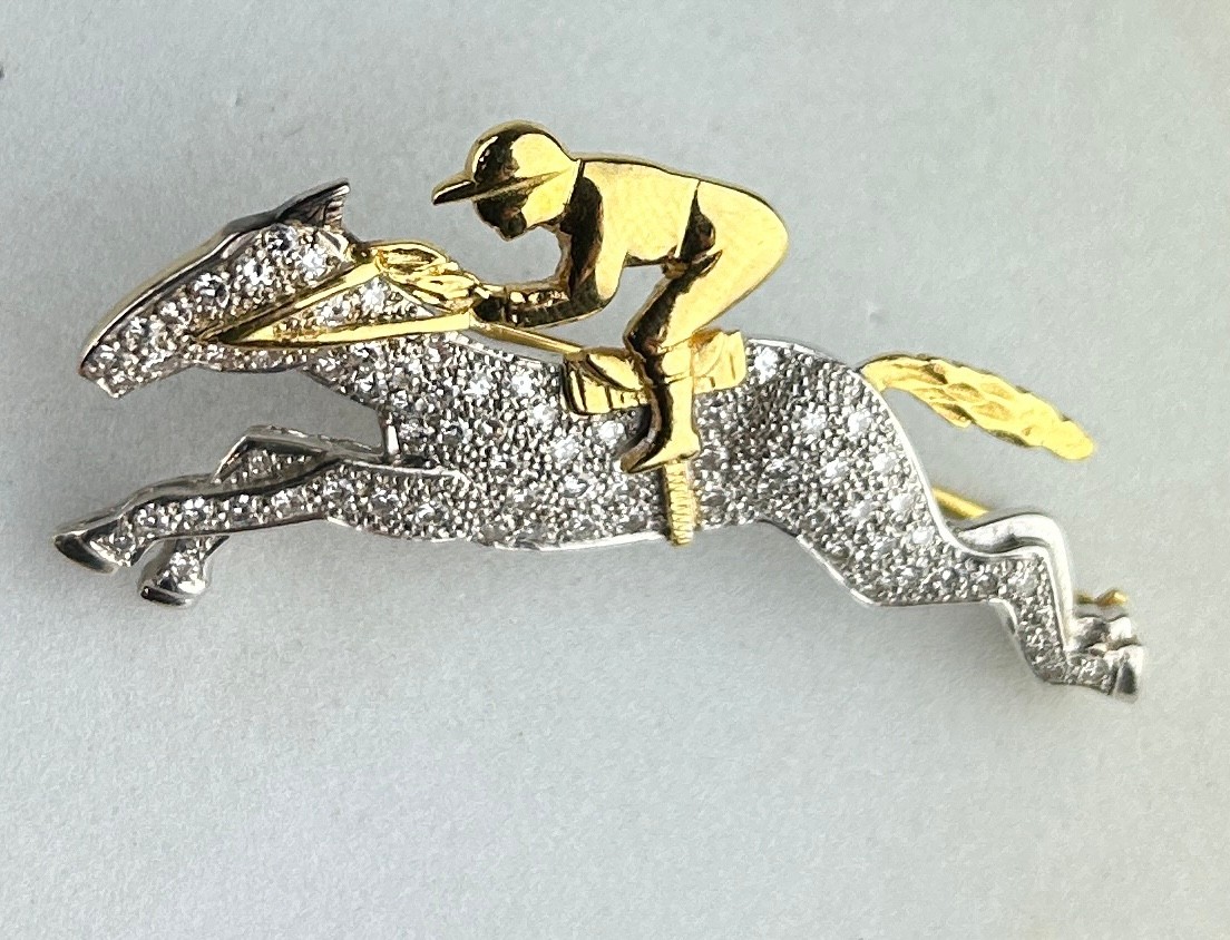 AN 18CT GOLD AND DIAMOND HORSE AND JOCKEY BROOCH, The brooch measures 4.7cm x 2.4cm.