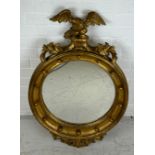 A GILT CIRCULAR WALL MIRROR WITH CARVED FRAME IN THE FRENCH IMPERIAL STYLE,