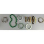 A COLLECTION OF FIVE CHINESE JADE OR STONE BANGLES ALONG WITH FIVE BELT HOOKS SOME IN THE ARCHAIC