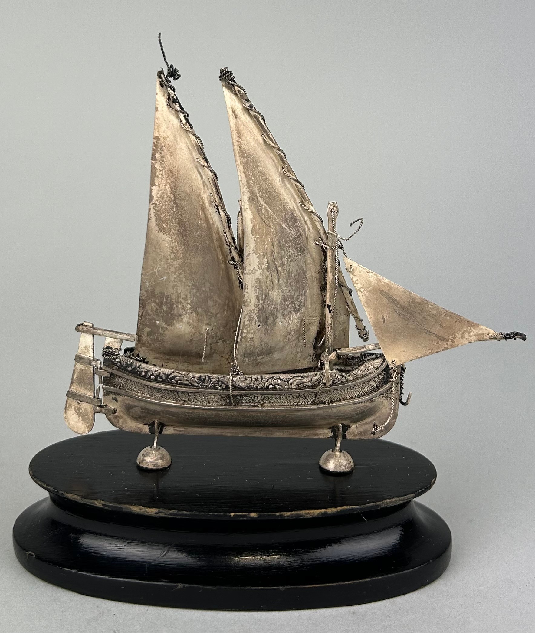 A SILVER JUNK SHIP MOUNTED ON STAND, 12cm x 12cm including stand.