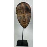 AN AFRICAN TRIBAL MASK, 23cm x 13cm Mounted on stand 38cm