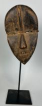 AN AFRICAN TRIBAL MASK, 23cm x 13cm Mounted on stand 38cm