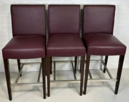 A SET OF THREE BAR STOOLS BY BEN WHISTLER UPHOLSTERED IN BURGUNDY LEATHER WITH WHITE BUTTON BACK,