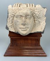 AN EAST ROMAN 'HAURAN' BASALT RELIEF FRAGMENT IN THE FORM OF A HUMAN HEAD CIRCA 2ND CENTURY A.D. The