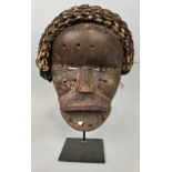 AN AFRICAN TRIBAL MASK WITH SHELL DETAIL, 26cm x 20cm Mounted on stand 32cm H