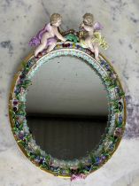 A MEISSEN PORCELAIN MIRROR WITH WINGED PUTTI CREST AND FLORAL BORDER, 34cm x 24cm