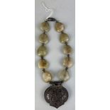 A JADE / STONE NECKLACE WITH WHITE METAL PENDANT