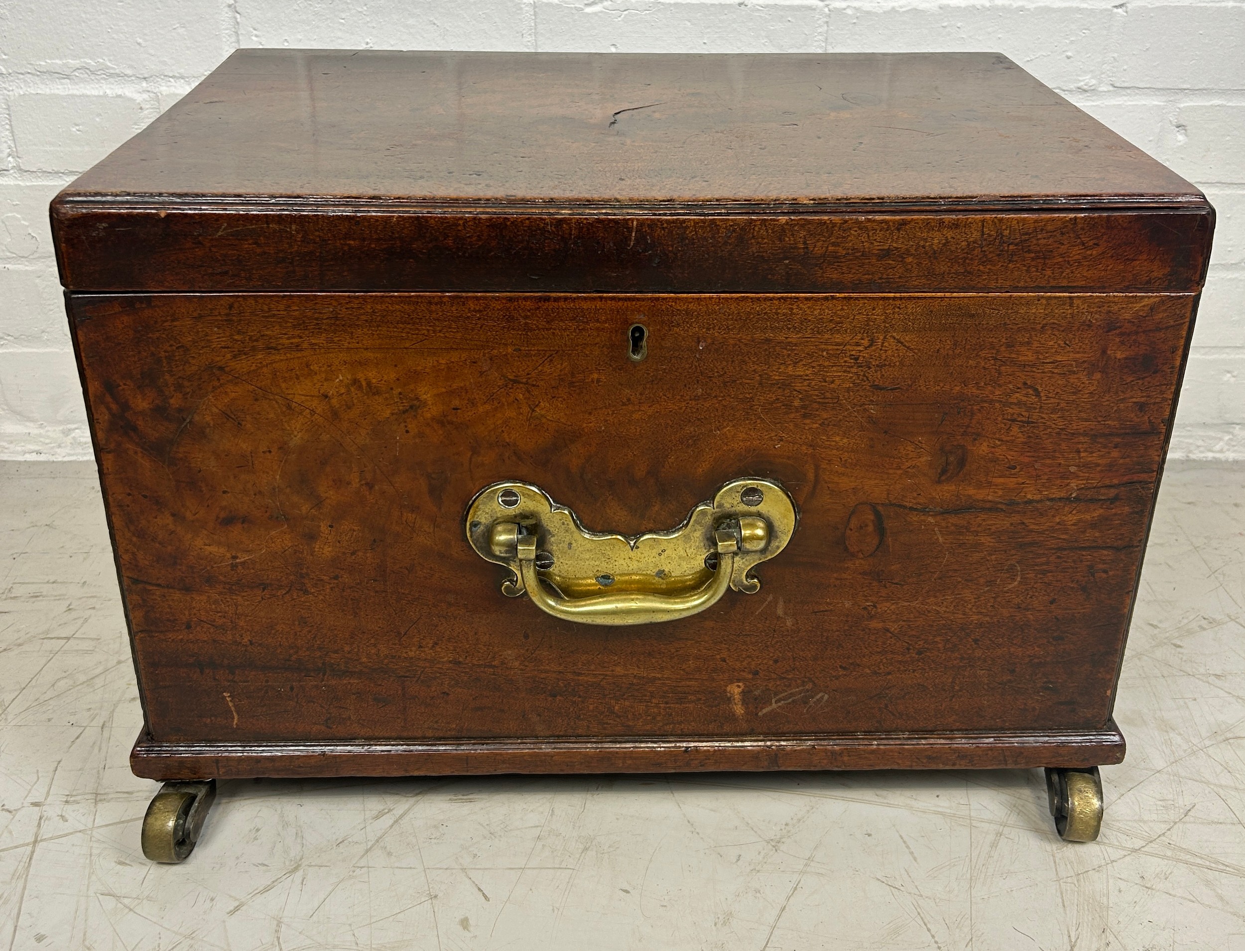 A GEORGE III MAHOGANY CELLARETTE, With fitted interior, brass handles and brass castors. 54cm x 38cm