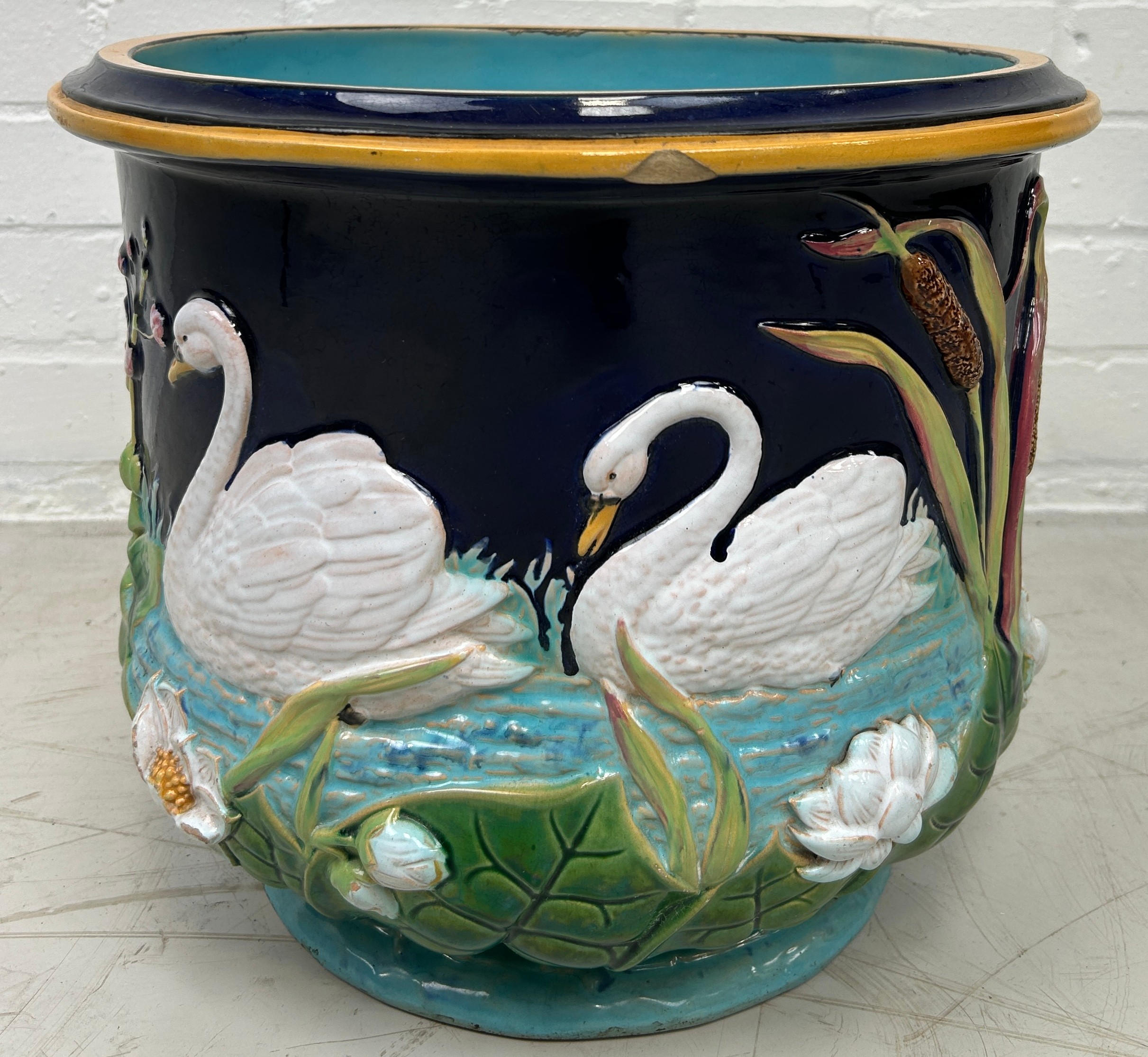 A GEORGE JONES MAJOLICA JARDINIERE DECORATED WITH SWANS, 37cm x 30cm