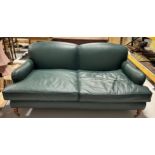 A LARGE TWO SEATER HOWARD STYLE SOFA UPHOLSTERED IN GREEN LEATHER FABRIC, Raised on four legs, the