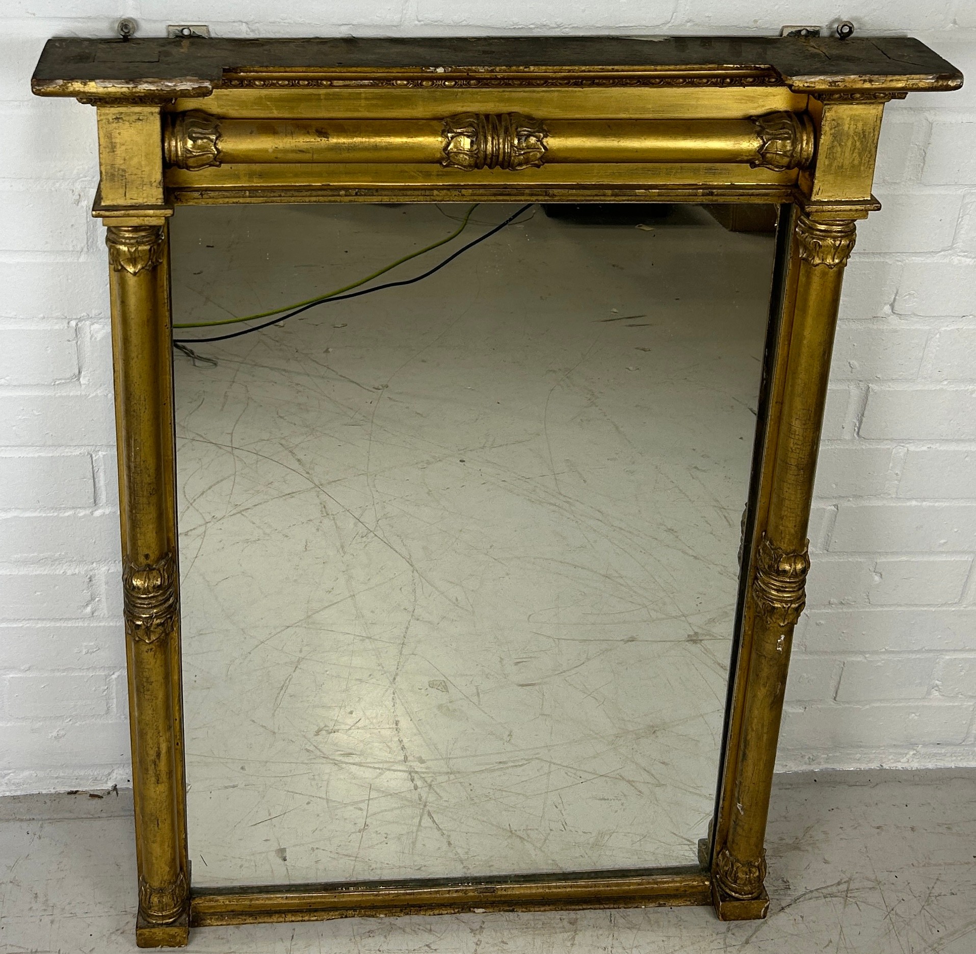 A REGENCY GILT WOOD WALL MIRROR, 93cm x 72cm Classical columns with floral capitals.