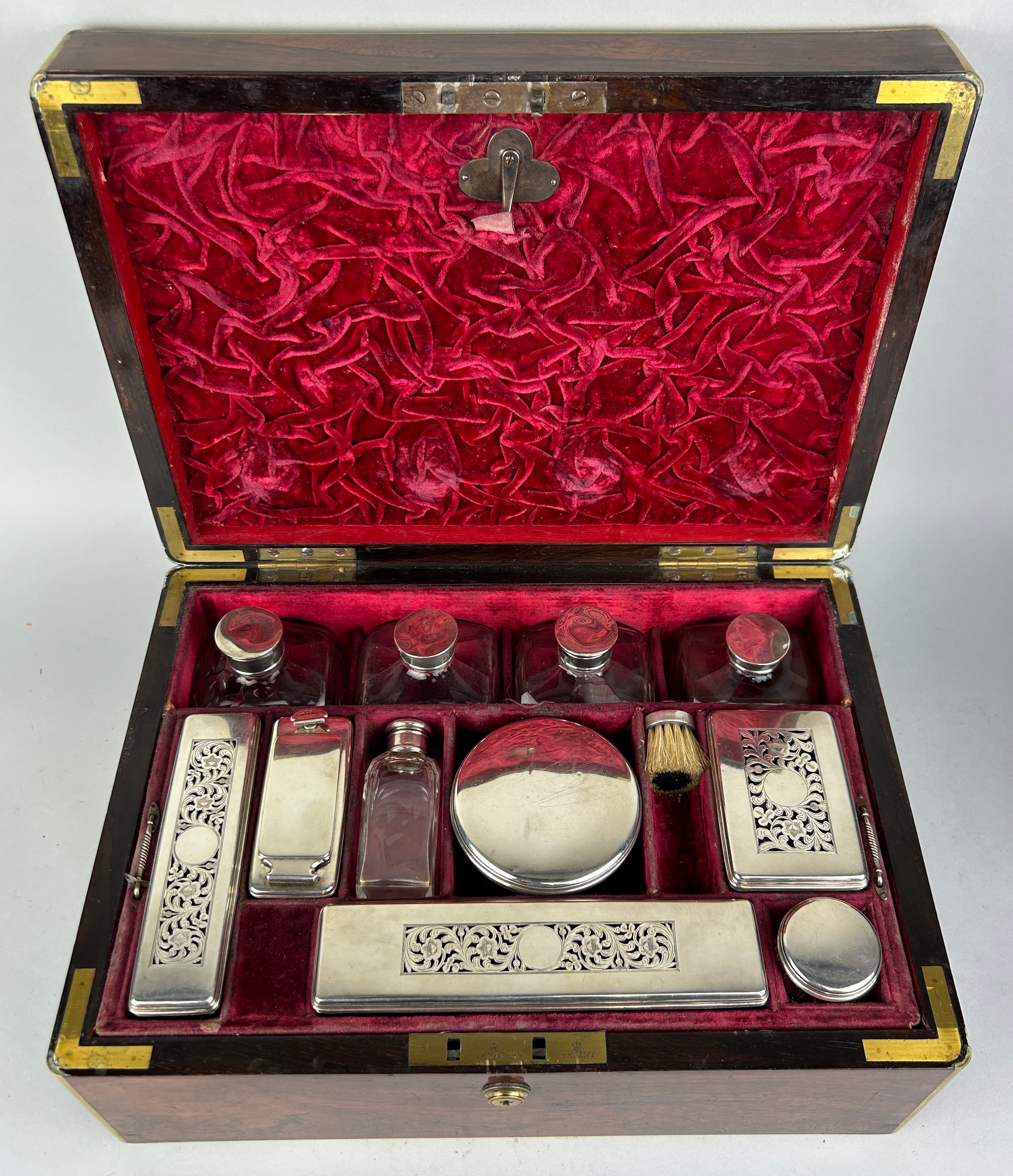 A 19TH CENTURY SILVER VANITY SET IN A CAMPAIGN BOX WITH BRASS HANDLES, 35cm x 25cm x 15cm