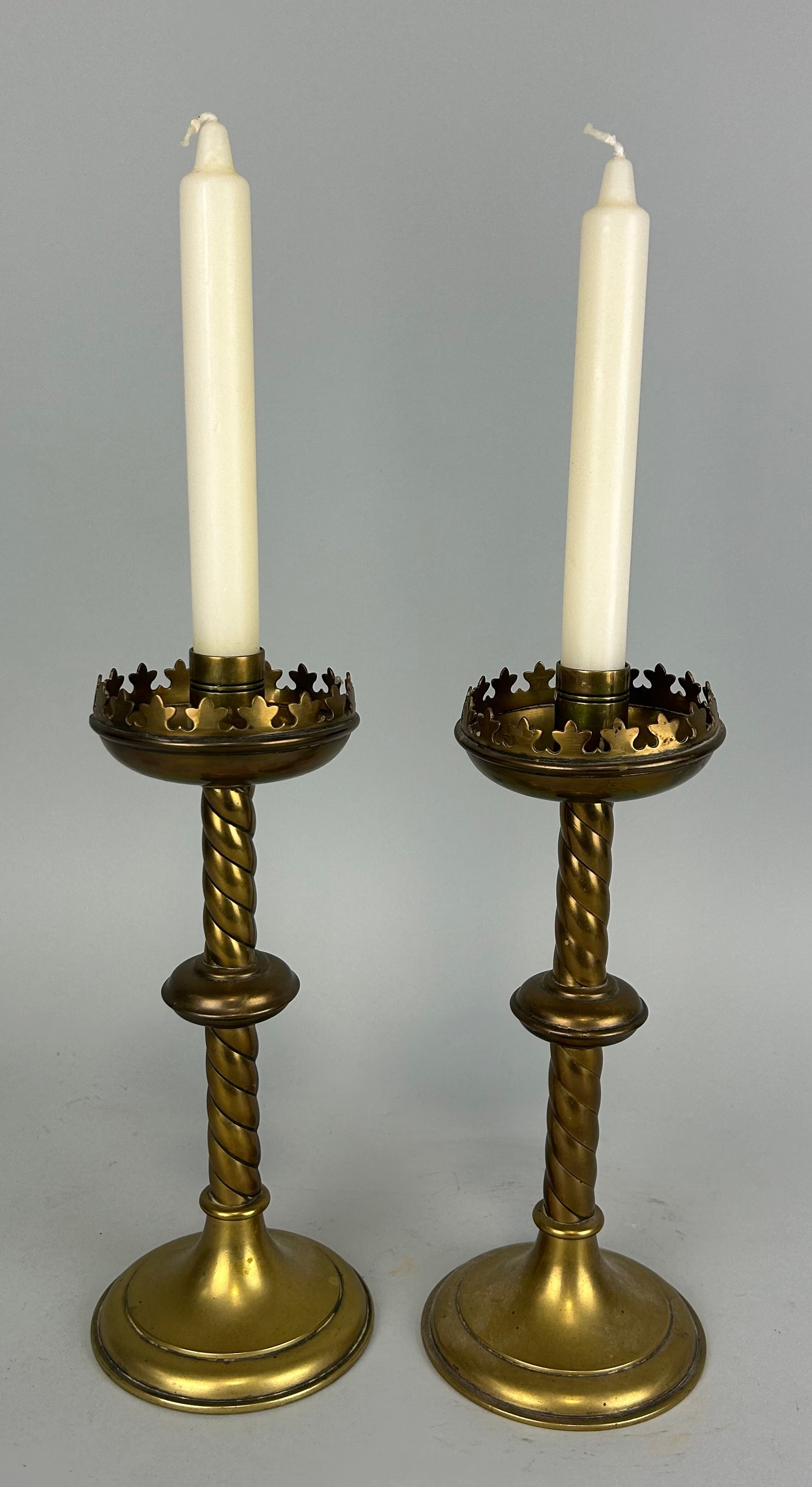 AFTER AWN PUGIN: A PAIR OF GOTHIC BRASS CANDLESTICKS 25cm H each.