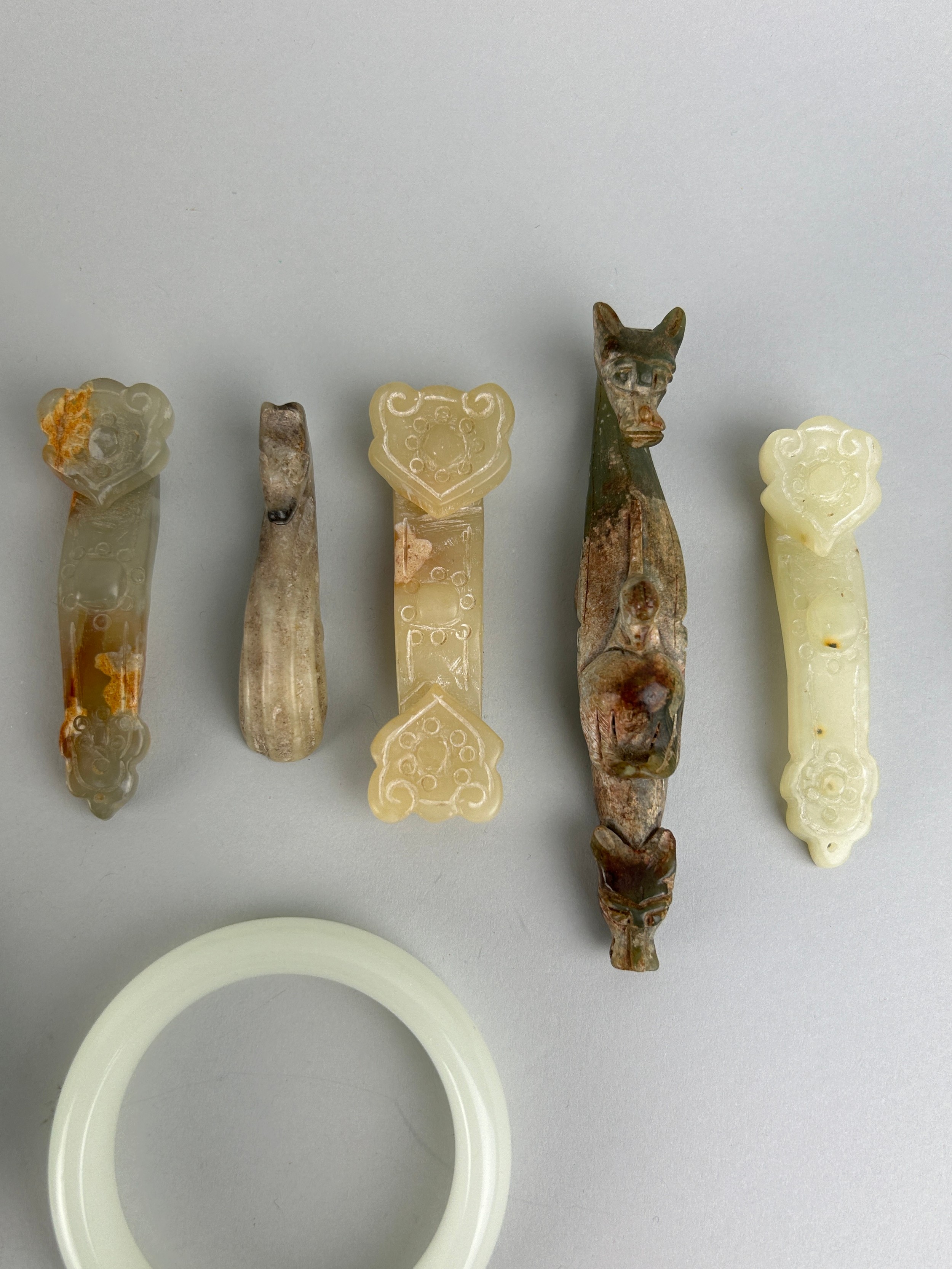 A COLLECTION OF FIVE CHINESE JADE OR STONE BANGLES ALONG WITH FIVE BELT HOOKS SOME IN THE ARCHAIC - Image 3 of 5