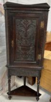 AN OAK CORNER CABINET POSSIBLY 19TH CENTURY CARVED WITH URNS AND FLOWERS, 176cm x 70cm
