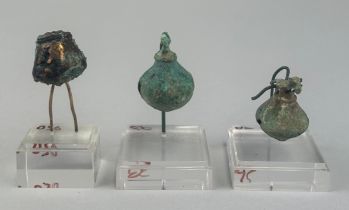 A GROUP OF THREE PRE-COLUMBIAN TUMBAGA BELL ORNAMENTS: Largest 3cm x 2cm Two with perspex stands.