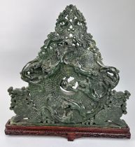 A LARGE CHINESE GREEN STONE SCULPTURE, 40cm x 40cm Mounted on a wooden stand.