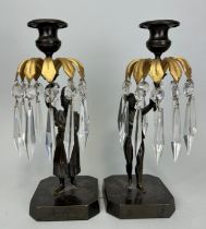 A PAIR OF BRONZE CANDLESTICKS DEPICTING MALE AND FEMALE FIGURES HOLDING WITH PALM LEAVES AND GLASS
