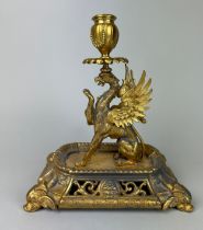 A GILT METAL CANDLESTICK IN THE FORM OF A PHOENIX, 25cm x 22cm