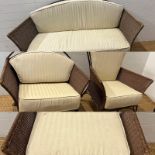 A metal rattan rustic garden suite comprising of a two seater sofa, his and her chairs, footstool