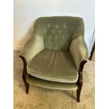 A Mid Century button back arm chair upholstered in green