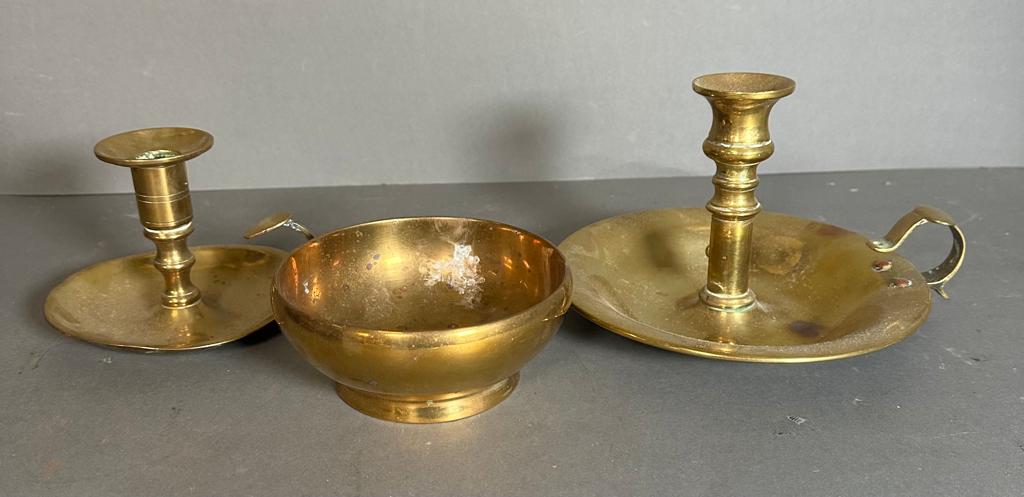 A selection of three brass items to include candle sticks and a bowl