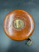 A Vintage Chesterman Constantia 66ft measuring tape with woven linen tape, a brass winder and a
