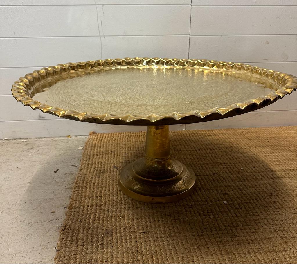 A brass engraved Middle Eastern tea table on brass engraved stand. Diameter 82 height 38