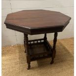 A mahogany octangular occasional table on turned supports with shelf under on castors (H71cm
