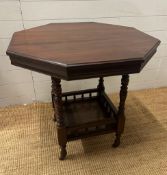 A mahogany octangular occasional table on turned supports with shelf under on castors (H71cm