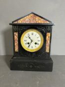 A French eight day enamel faced slate mantel clock with scrolling relief