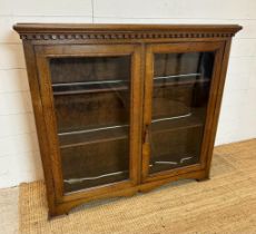 An oak glazed lockable bookcase with key (H95cm W107cm D28cm)