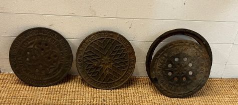 Three reclaimed metal man hole covers