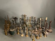 A large selection of candle sticks various sizes and ages