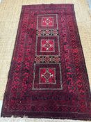A red ground wool rug with geometric central medallions