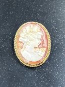 A 9ct god and cameo brooch, lady in classical pose.(Approximate weight 5g and 28mm high)