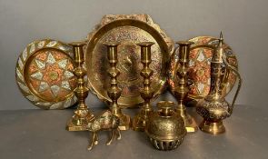 A selection of brass items to include candlesticks, plates and an elephant claw bell