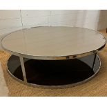 An Italian contemporary circular smoked glass coffee table on chrome frame by Minotti (H34cm