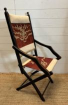 A lacquered wooden folding campaign chair with red and white floral seat and back