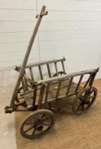 A vintage wooden dog cart or garden trolley with metal bound wheels